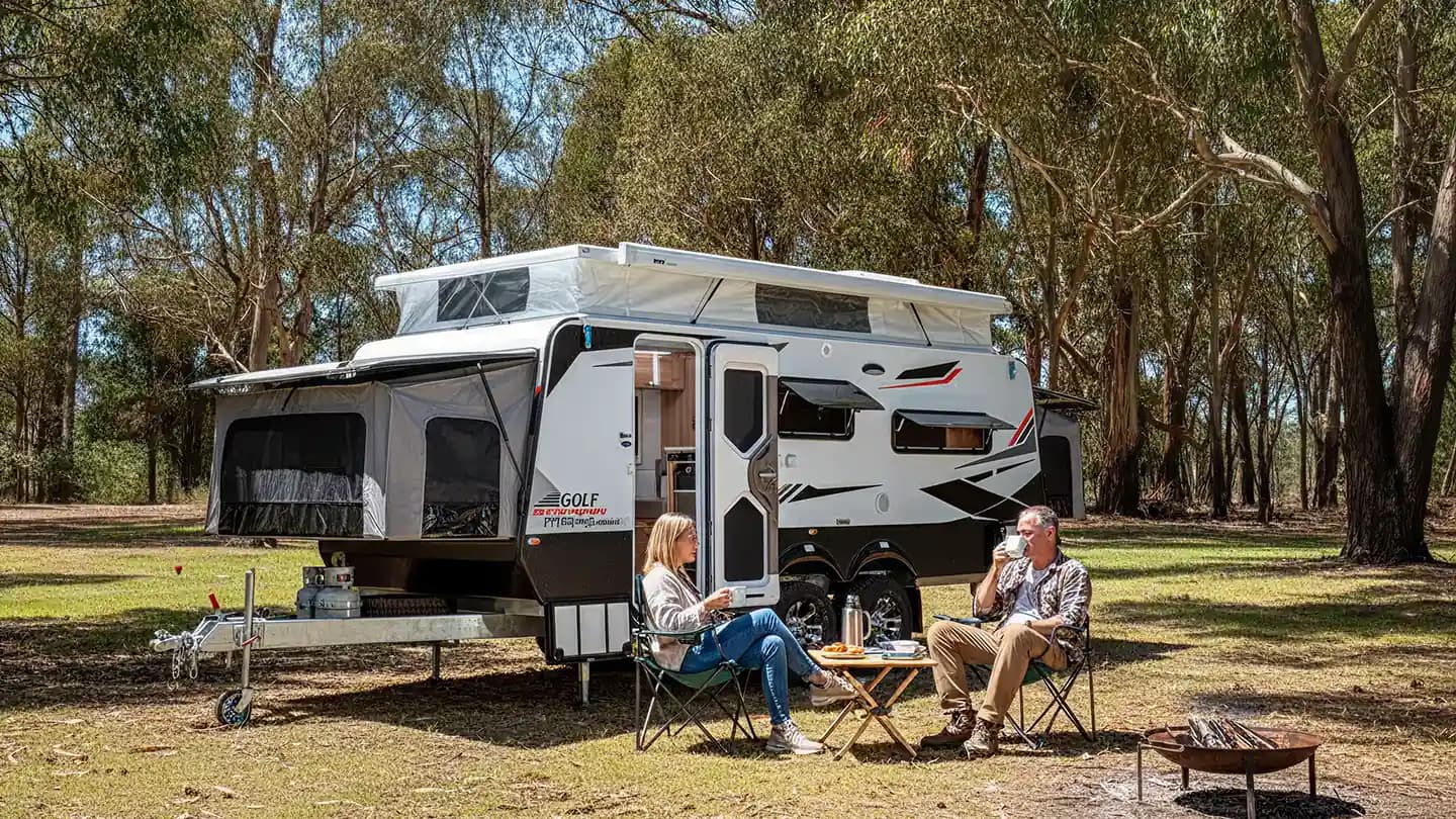 Golf caravan set up at a campsite in the trees